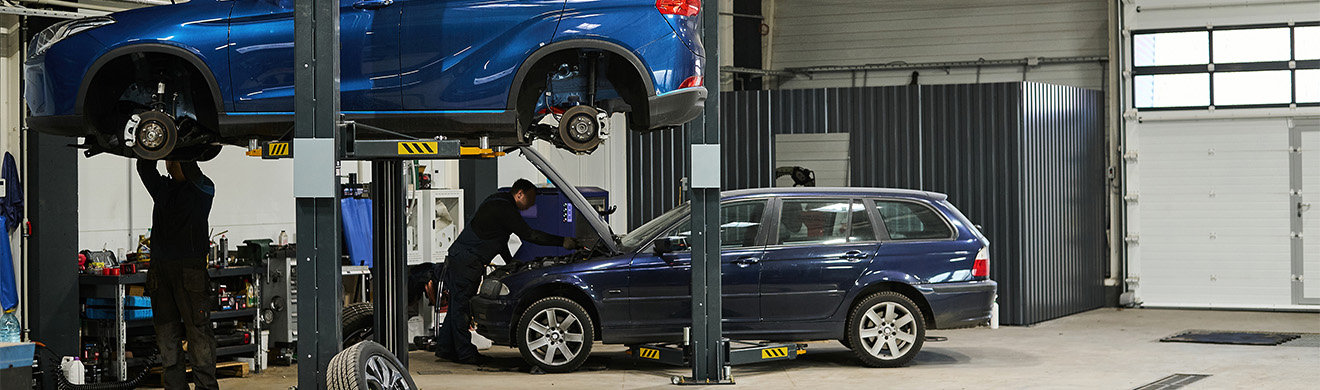 Auto auf Hebebühne in Werkstatt bei Autoreparaturen in Schleiden, Mechaniker prüft Fahrzeug während Wartungsarbeiten und Diagnosearbeiten durchgeführt werden