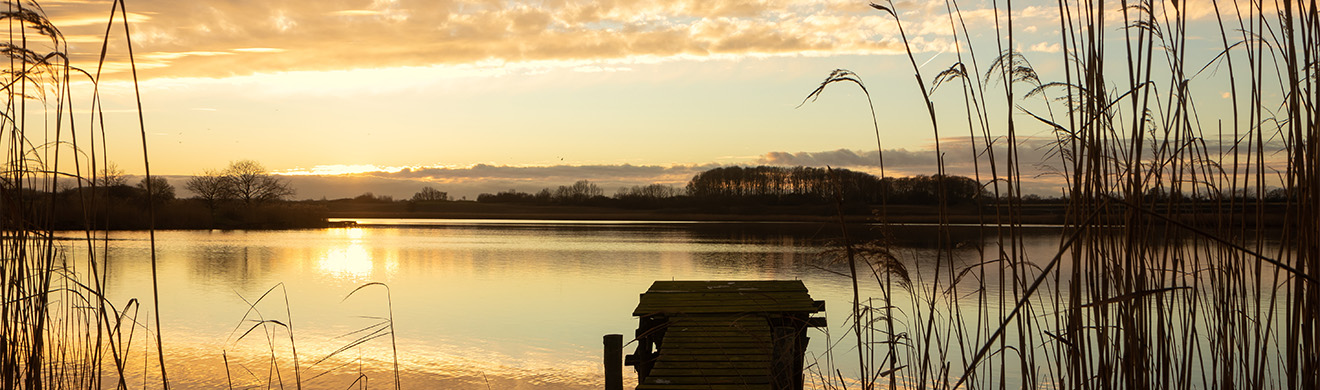 Ruhiger See bei D&auml;mmerung mit spiegelnder Wasseroberfl&auml;che und friedlicher Naturstimmung zur Bestattungsvorsorge in Kall Region Nordrhein-Westfalen