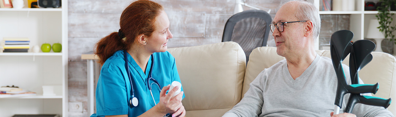 Pflegefachkraft erklärt älterem Mann in ruhiger Umgebung Medikamente und unterstützt ihn im Alltag der häuslichen Pflege in Mechernich.