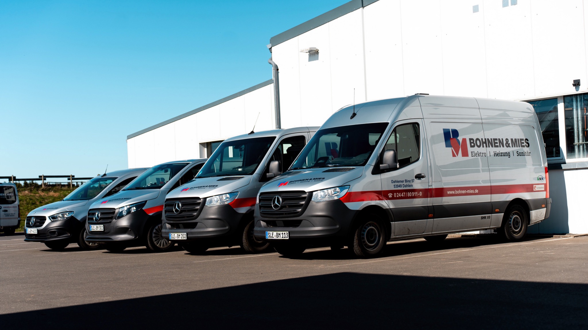 Fuhrpark der Firma Bohnen u. Mies auf dem Außengelände mit Servicefahrzeugen für Heizungs-, Sanitär- und Haustechnikarbeiten.