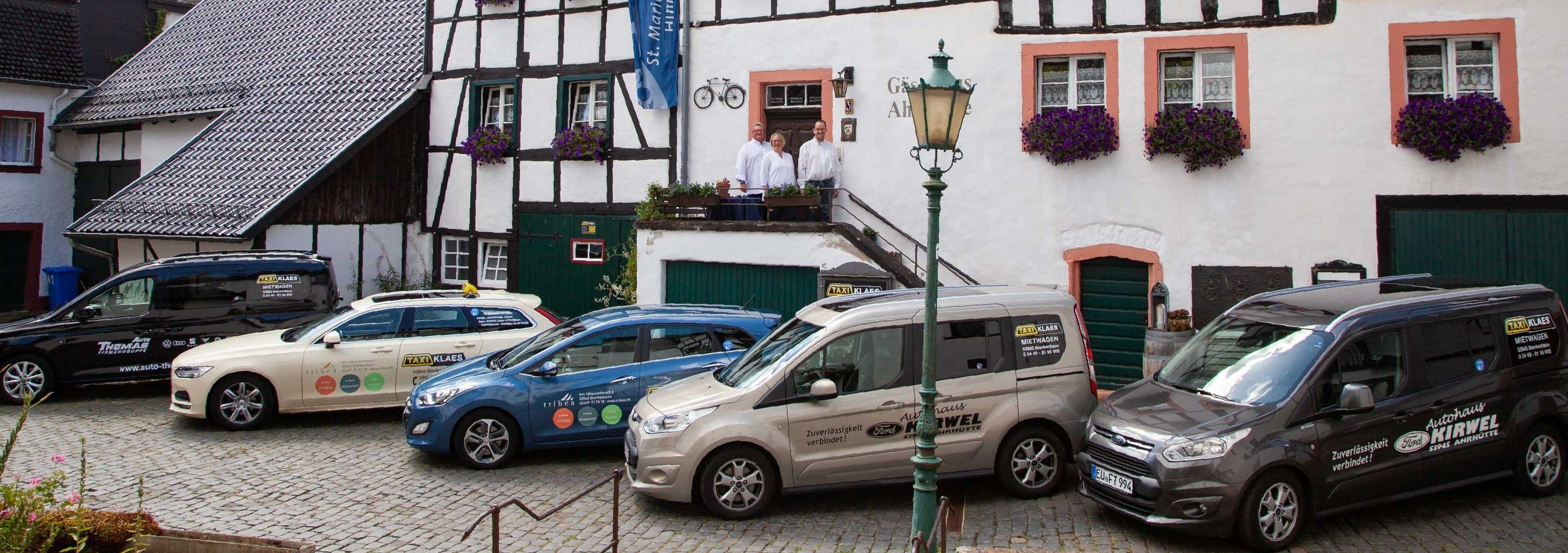 Außengelände von Taxi Klaes in Blankenheim mit mehreren Taxifahrzeugen und Inhaber vor dem Firmenstandort.