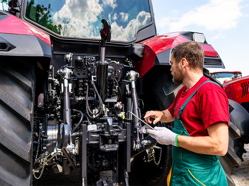 Mechaniker überprüft Traktor mit Tablet bei Wartung und Diagnose einer Landmaschine reparieren in Blankenheim.