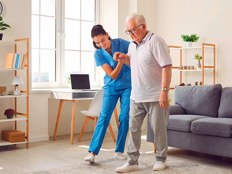 Pflegedienst-Mitarbeiter unterstützt älteren Mann beim Gehen, bietet individuelle Pflege und Begleitung in Bad Münstereifel.
