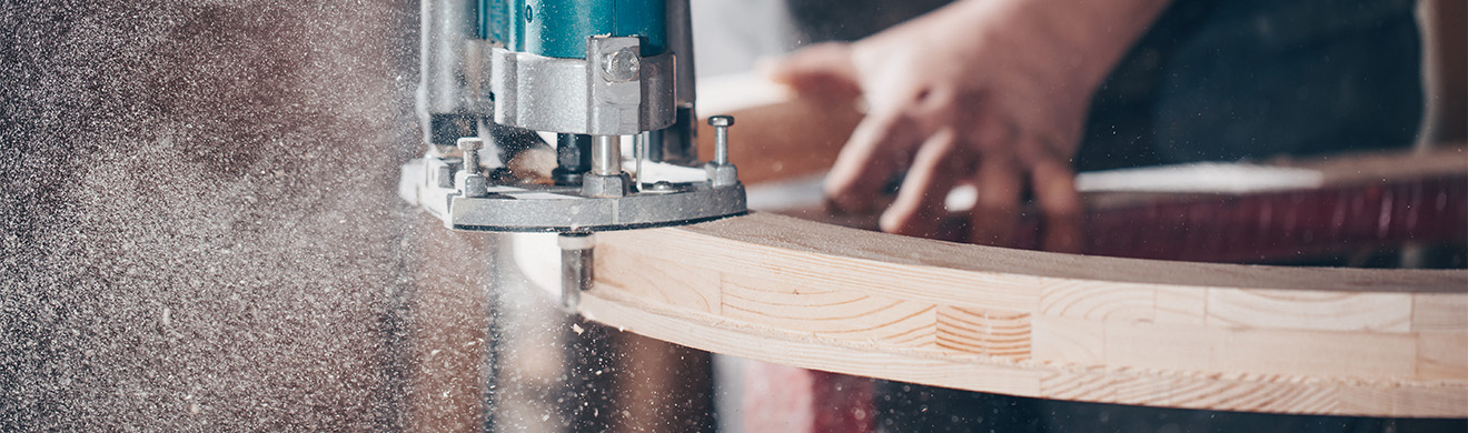 Tischler in Euskirchen schneidet Holz präzise in der Werkstatt, bearbeitet Bauteile für Möbel und Inneneinbau professionell und konzentriert.